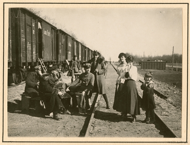 German_officers_conversing_with_women_and_child_in_rail_yard_(8672042109)